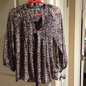 Sheer print top. Pleated v-neck bib. Long sleeves with elastic cuffs.